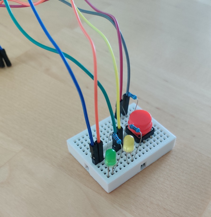 Image of a breadboard with a button and two LEDs